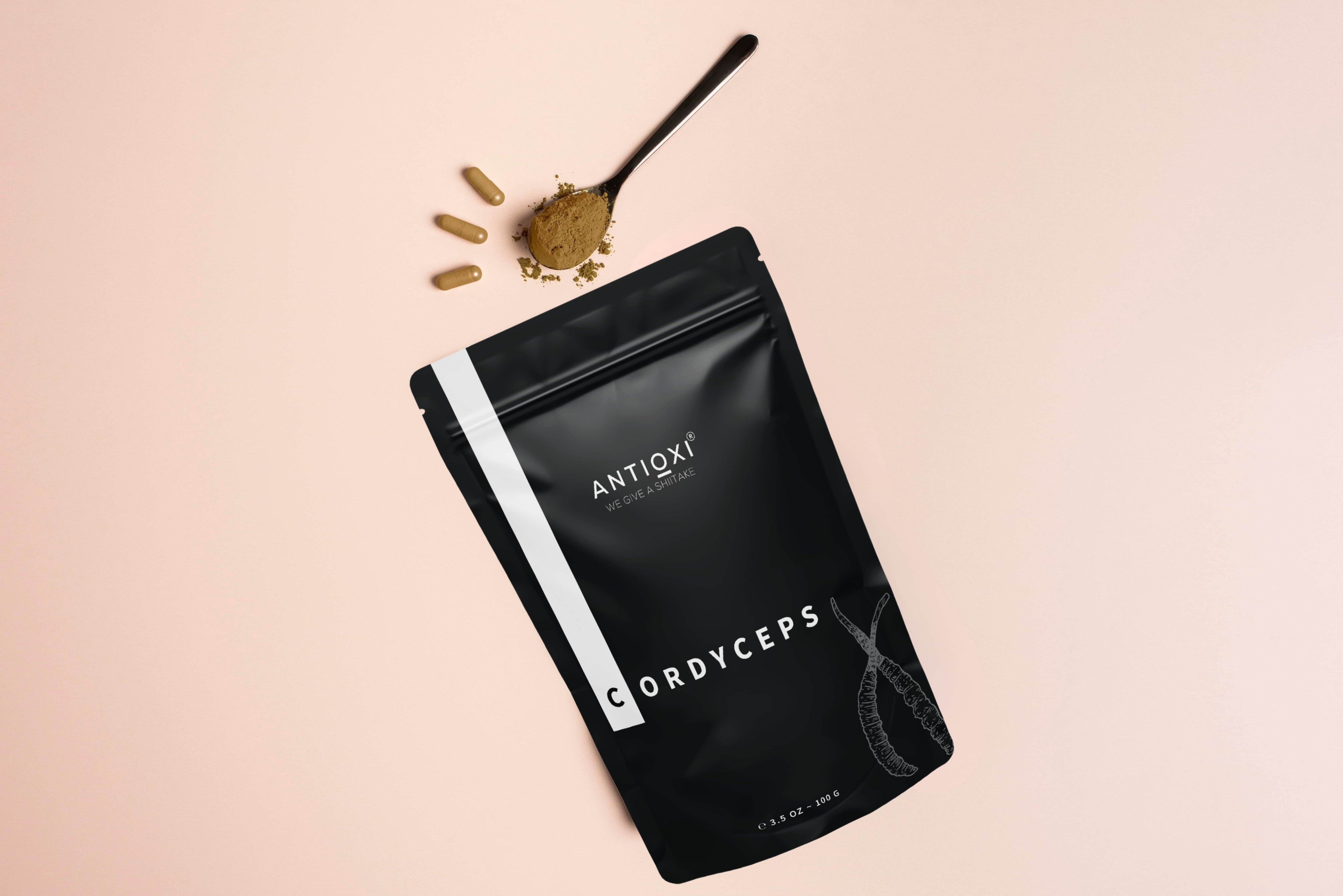 Antioxi Cordyceps mushroom extract with capsules and powder on a soft beige background.